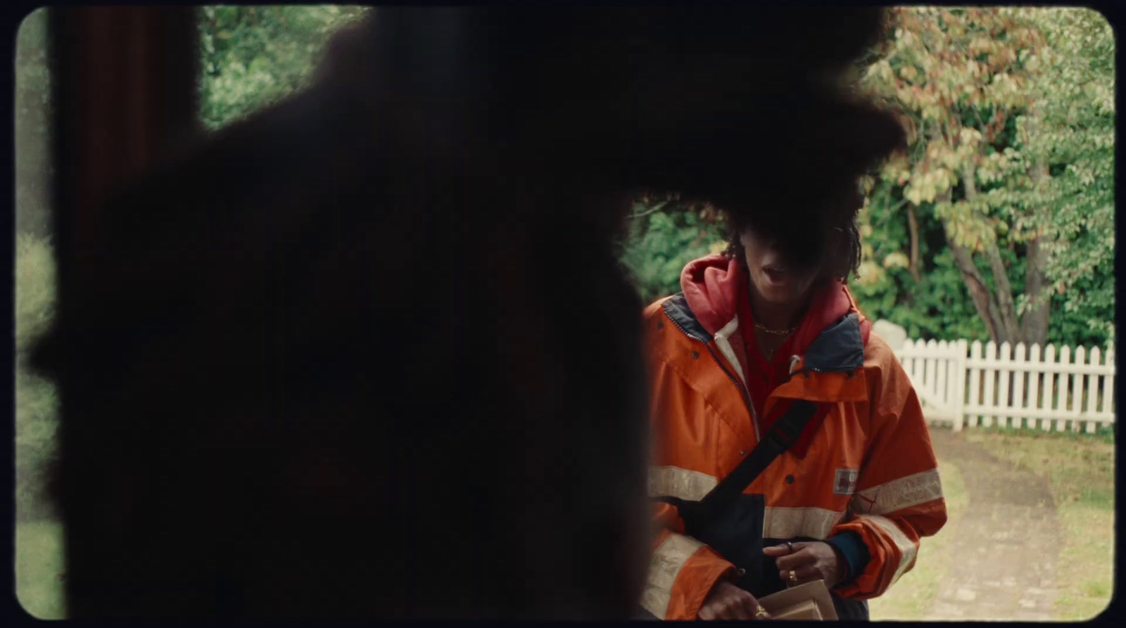 a man in an orange jacket is looking at something