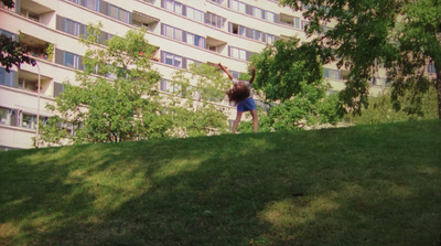 a person jumping in the air in front of a building