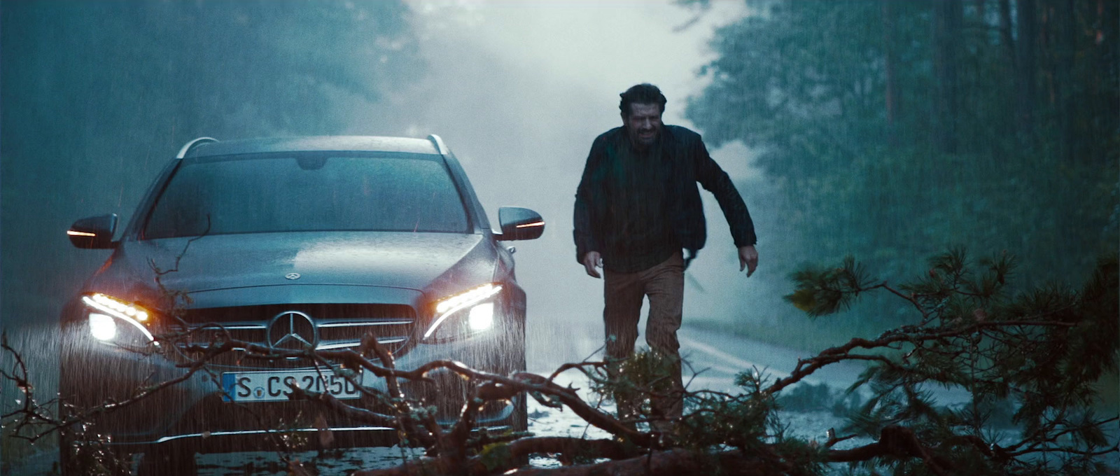 a man standing next to a car in the rain