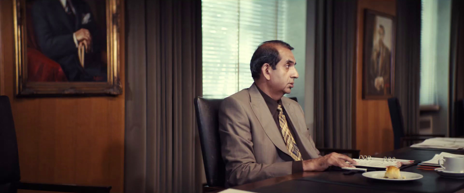 a man sitting at a desk with a plate of food