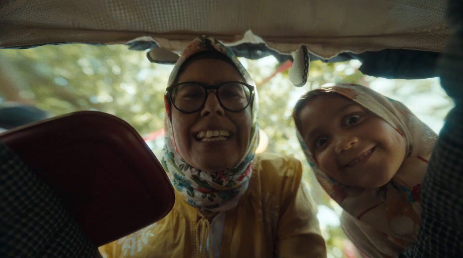 a man and a woman sitting in the back of a car