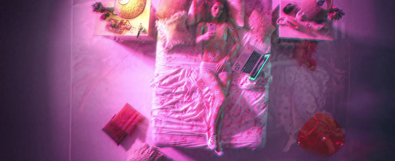 a woman in a pink dress laying on a bed