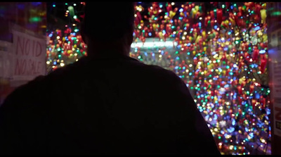 a man standing in front of a christmas light display