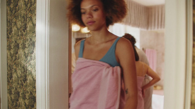 a woman standing in a doorway with a towel on her back