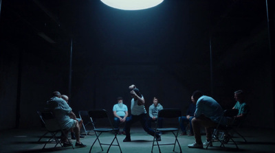 a group of people sitting in chairs in a dark room