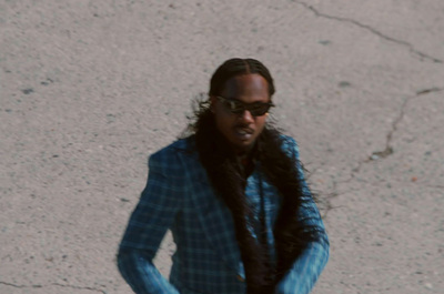 a man in a blue suit and sunglasses is holding a skateboard