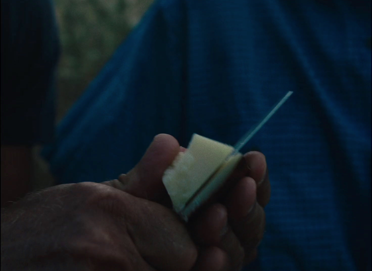 a man holding a piece of cheese in his hand