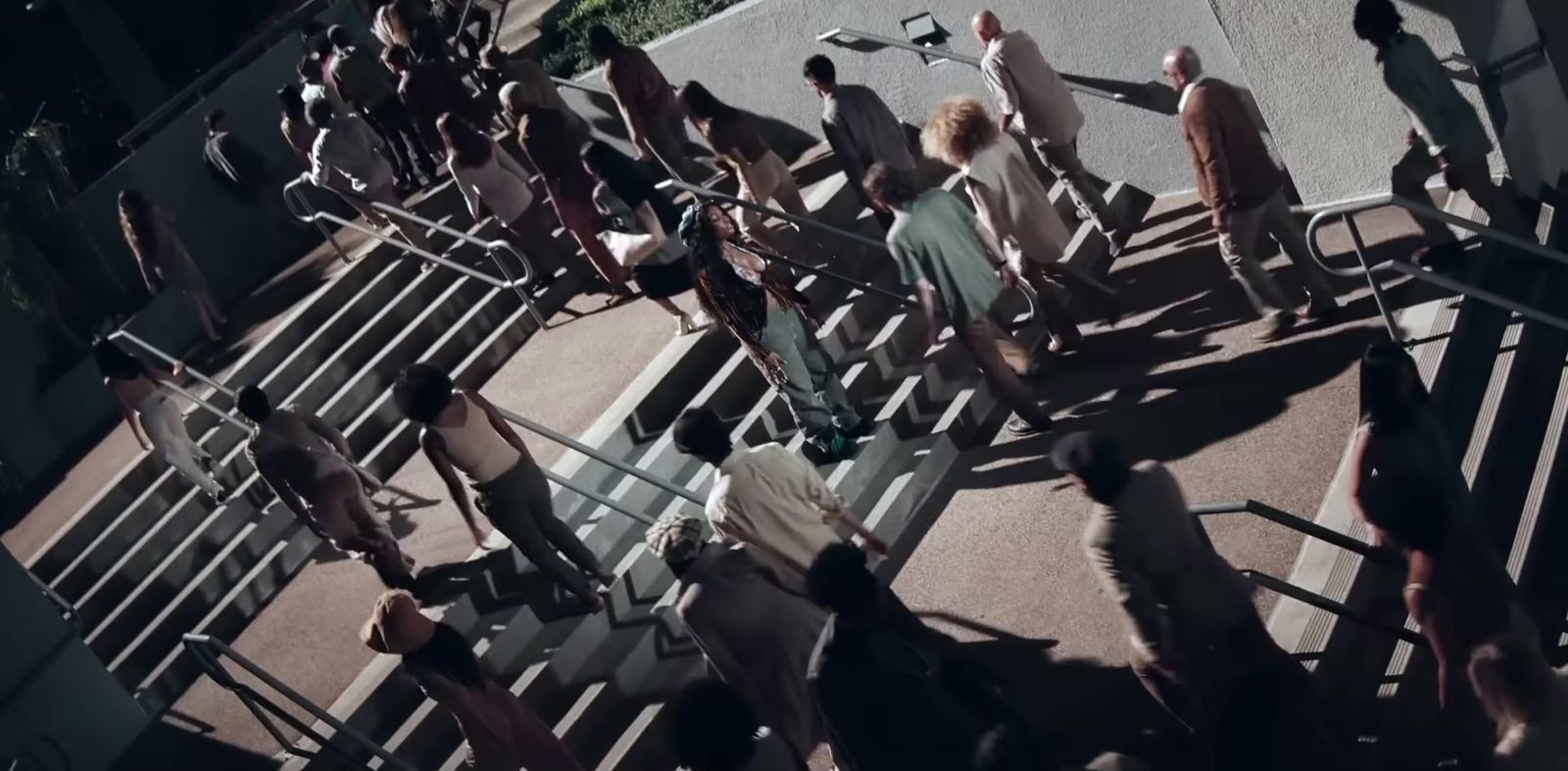 a crowd of people standing on top of a sidewalk