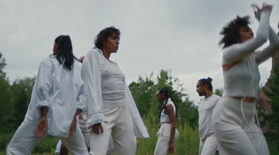 a group of women in white clothes are dancing