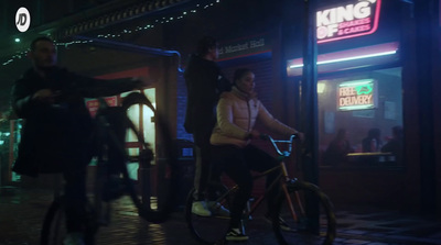 a man riding a bike down a street at night