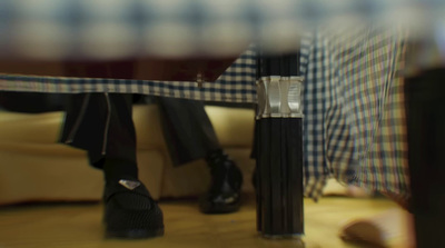 a person sitting on a couch next to a black and white checkered chair