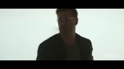 a blurry image of a man wearing glasses