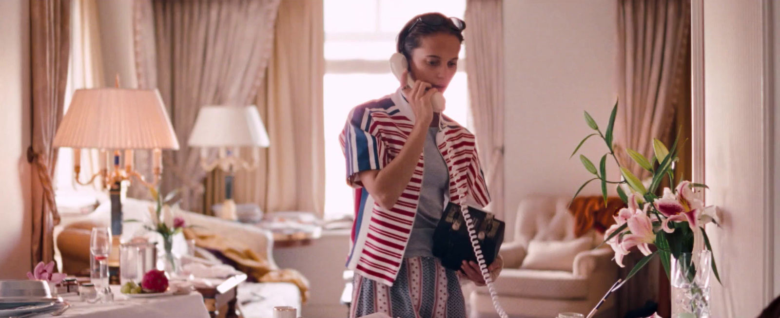 a woman standing in a living room holding a purse