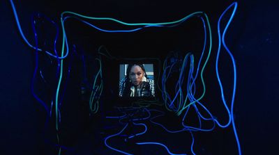 a woman is seen through a tunnel of neon lights