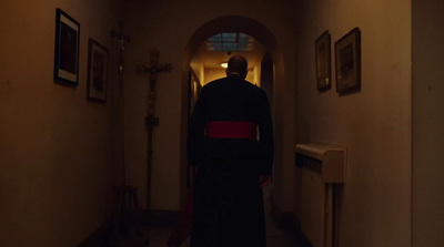 a man in a robe is walking down a hallway