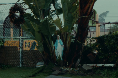 a woman standing next to a tree in a yard