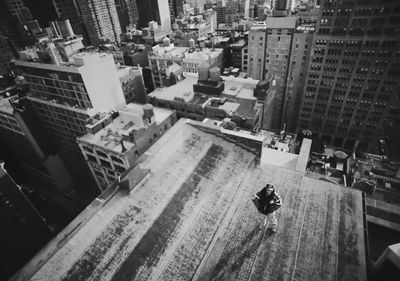 a person standing on top of a roof in a city