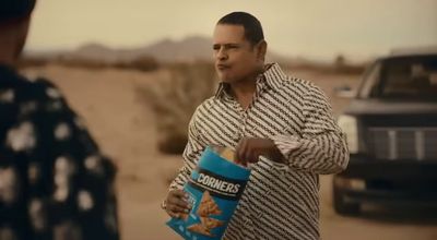 a man holding a bag of cornflakes next to a truck