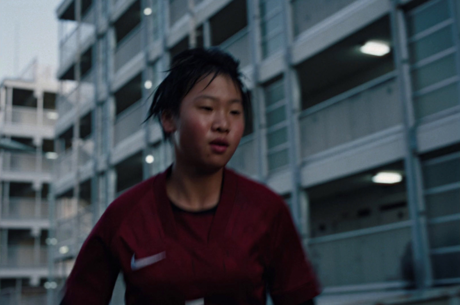 a woman in a red shirt standing in front of a building