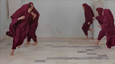 a group of people in red robes dancing in a room