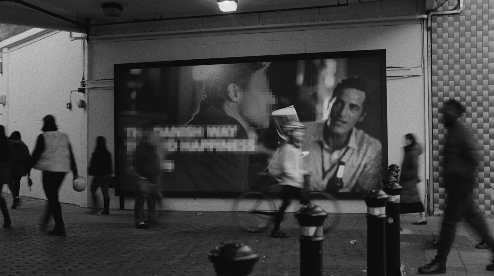 a black and white photo of people walking past a movie poster