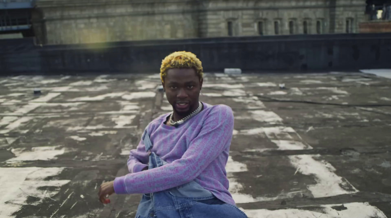 a man sitting on top of a roof next to a building