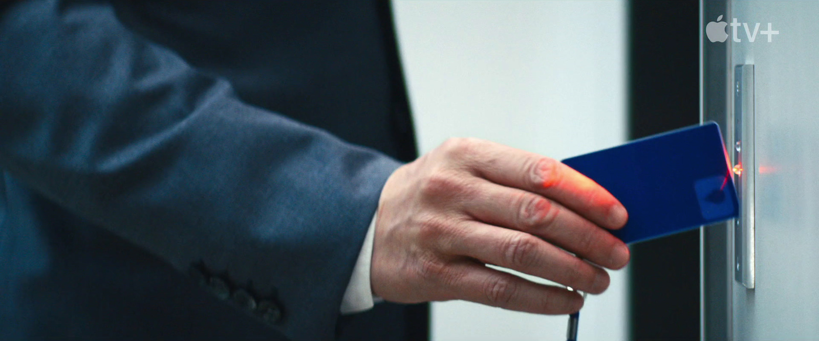 a man in a suit is holding a blue object