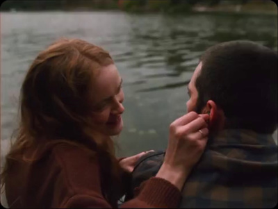 a man and a woman standing next to a body of water