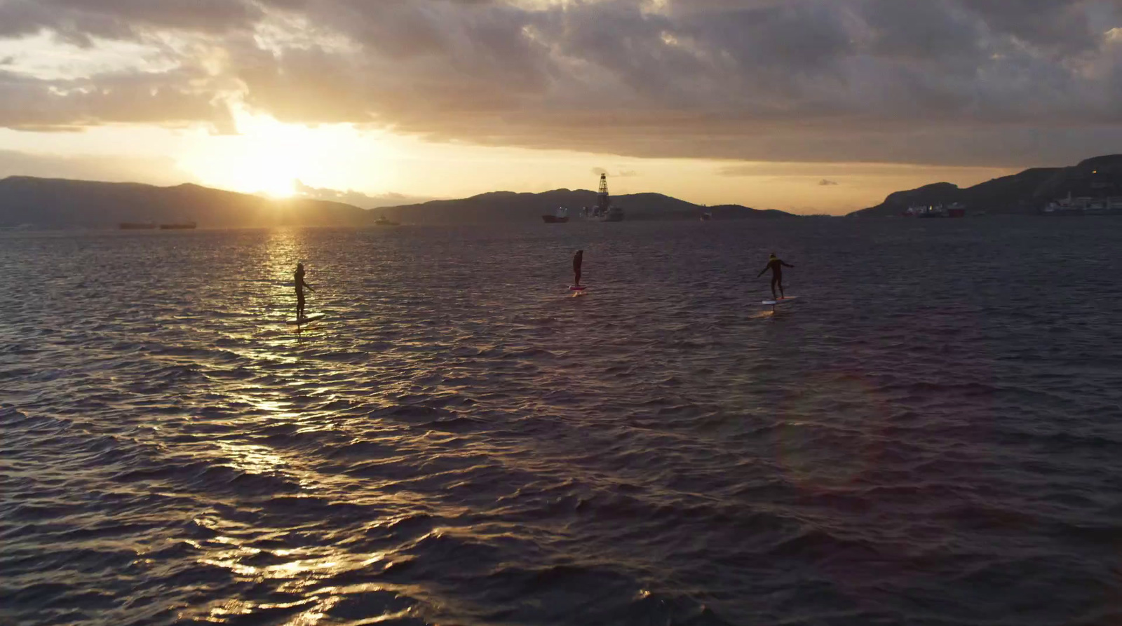 a group of people riding surfboards on top of a body of water