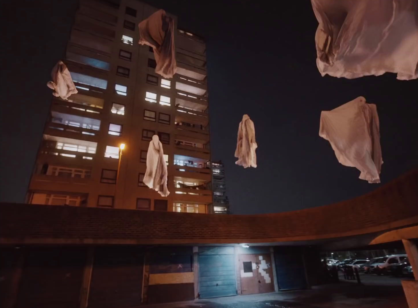 a group of umbrellas hanging from a building at night