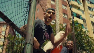 a man holding a white frisbee next to a net