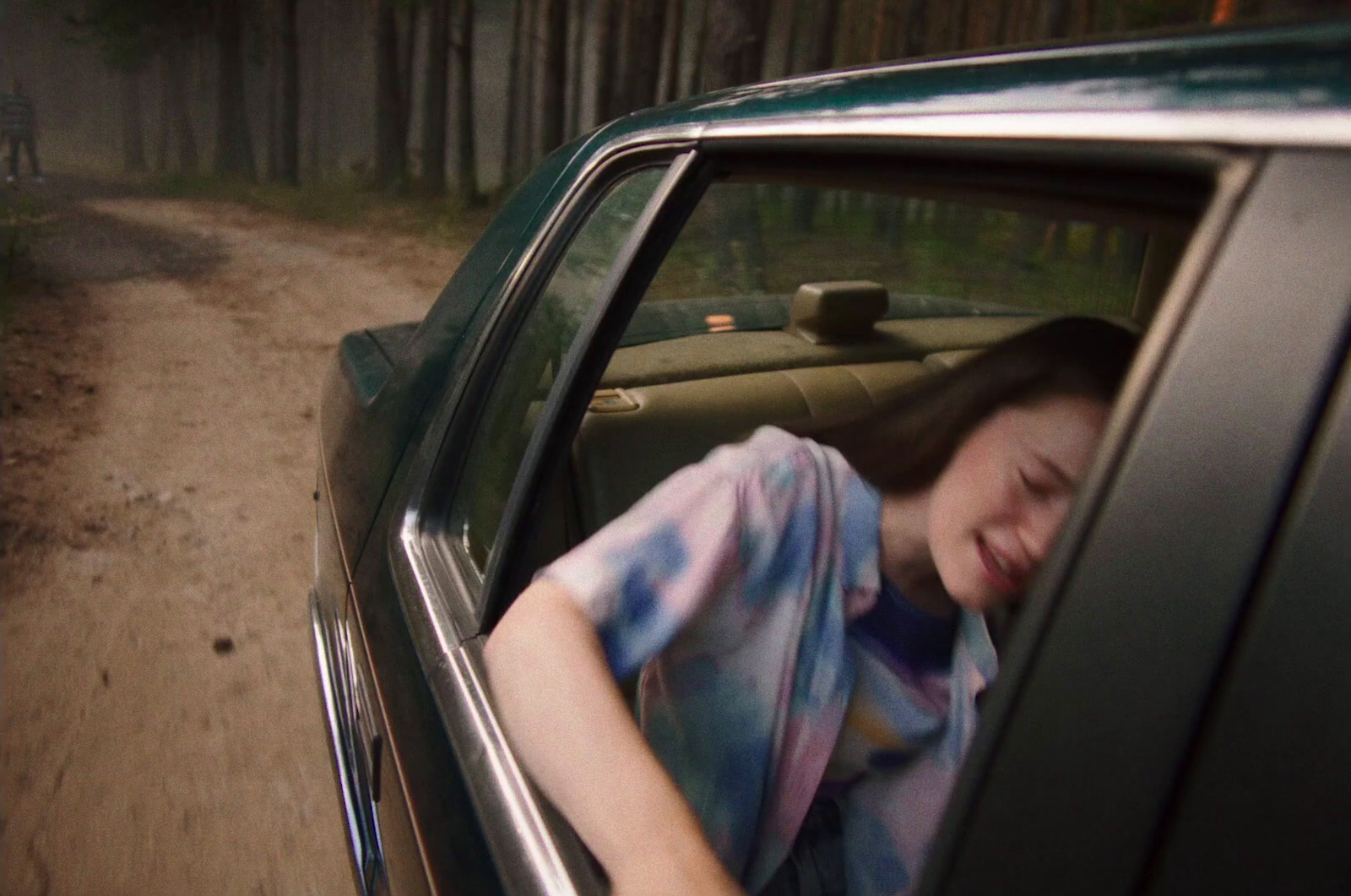 a woman sitting in a car with her head out the window