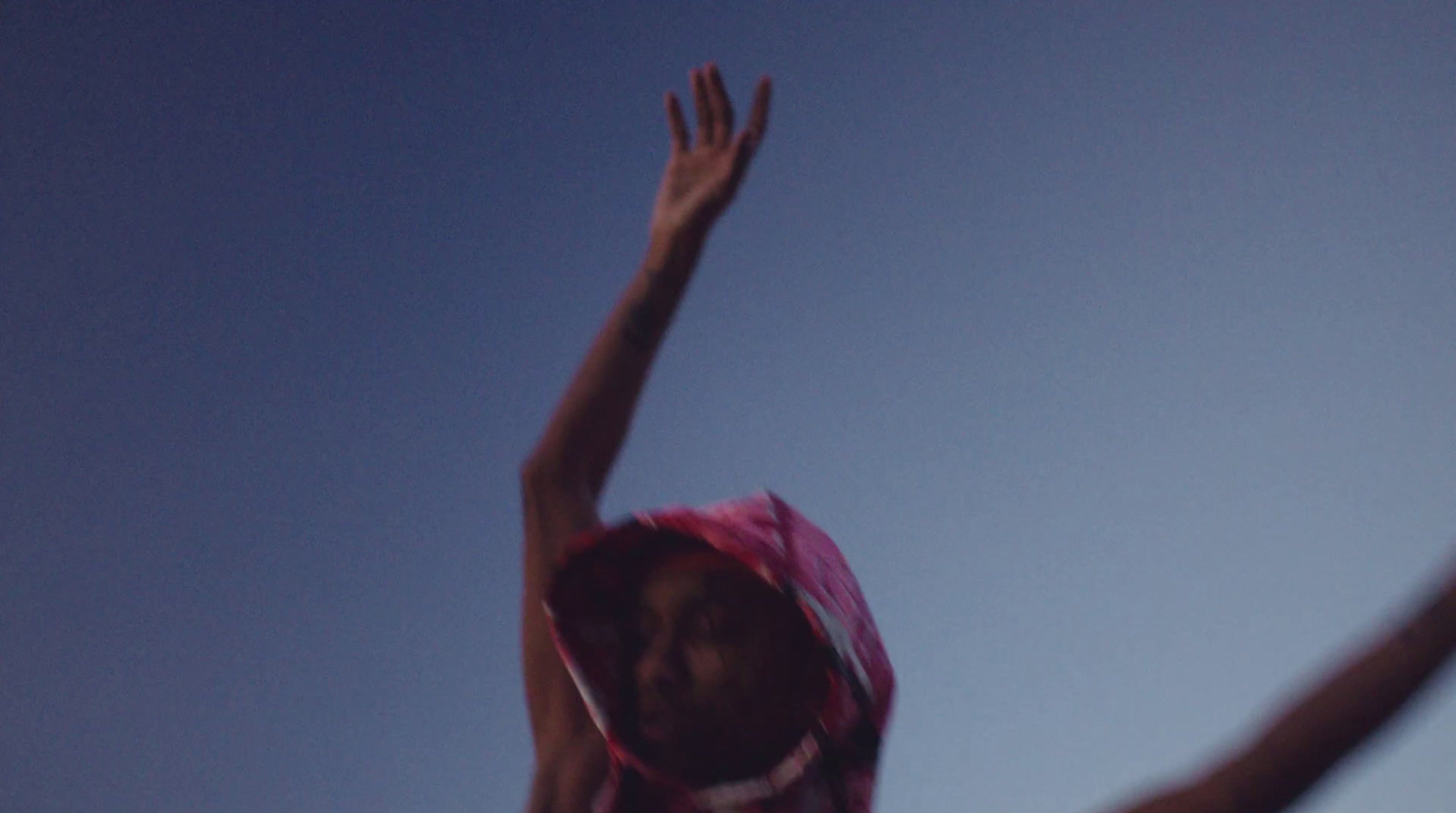 a woman reaching up to catch a frisbee