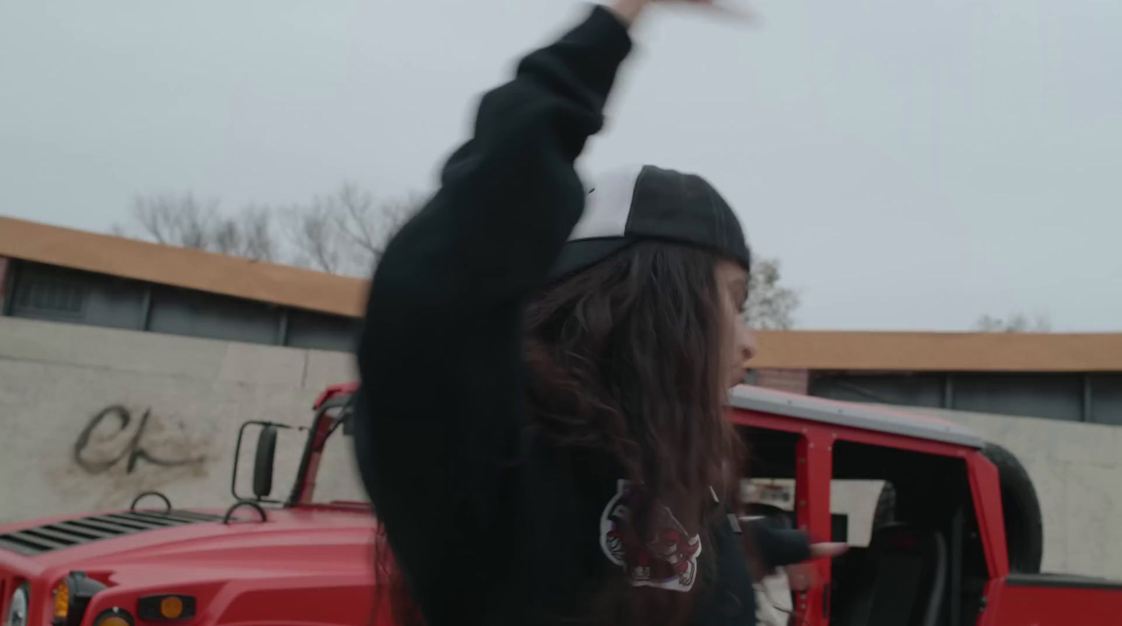 a woman in a black shirt and hat standing in front of a red truck