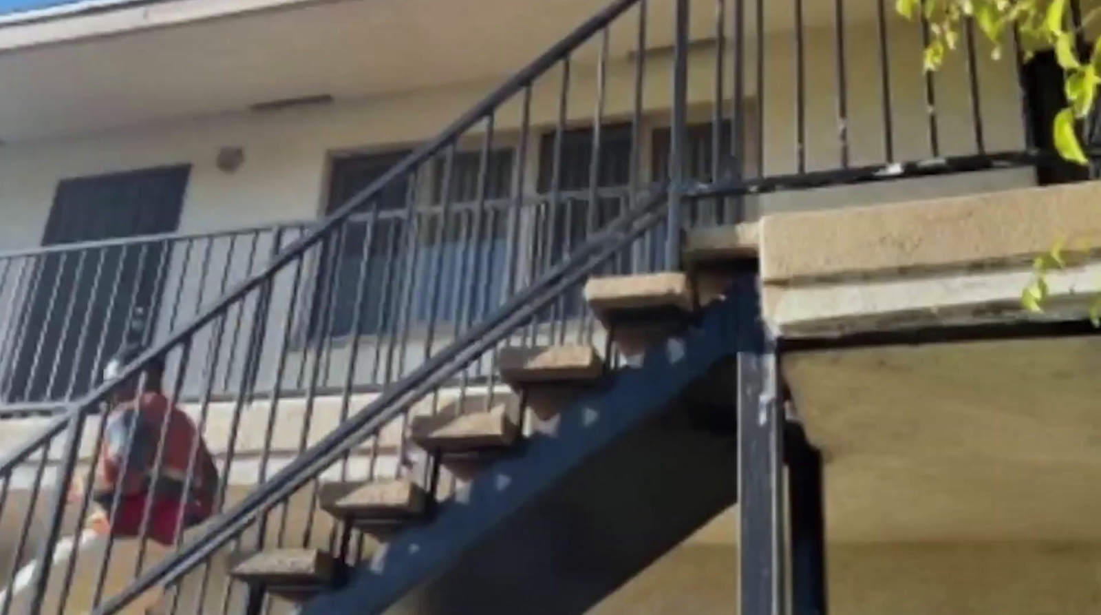 a man walking down a set of stairs next to a building