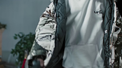 a person wearing a jacket with a camo print on it