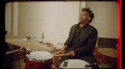 a man sitting in front of a drum set