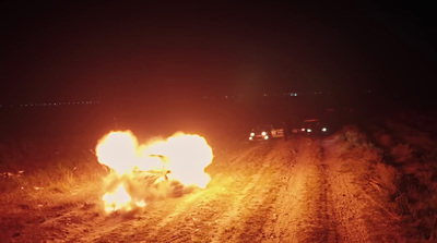 a car that is on fire on a dirt road