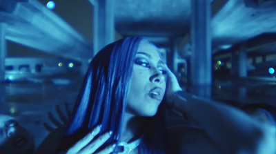 a woman with blue hair is holding a cell phone