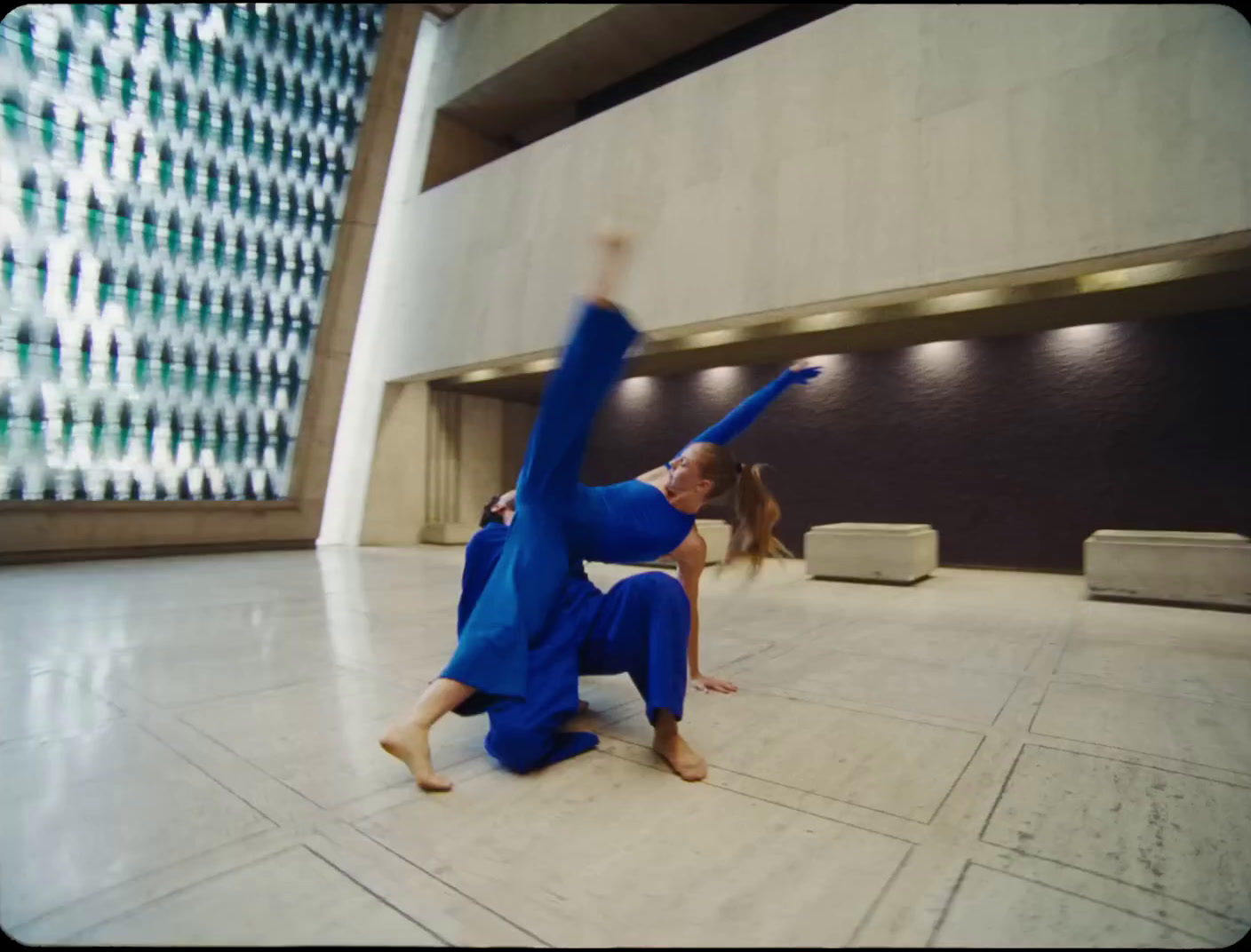 a woman in a blue jumpsuit doing a handstand