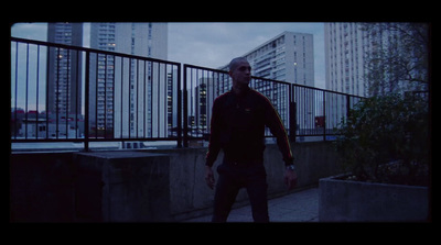 a man walking down a sidewalk next to tall buildings