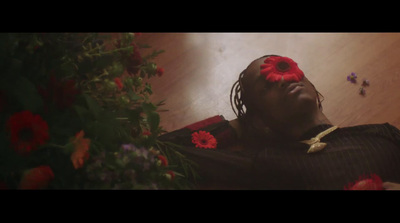 a woman laying on the floor with a flower in her hair