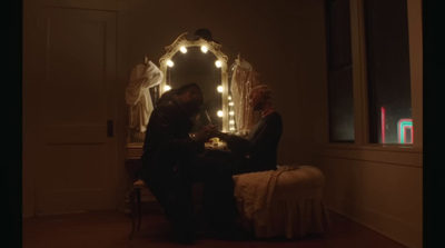 two people sitting at a table in front of a mirror