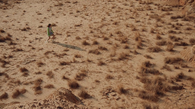 a little girl is flying a kite in the desert