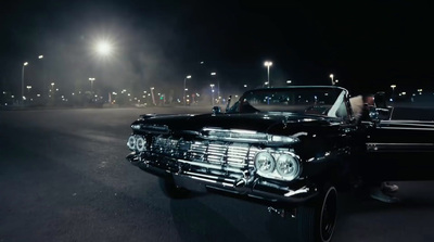 a black car parked in a parking lot at night