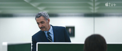 a man in a suit and tie sitting at a desk