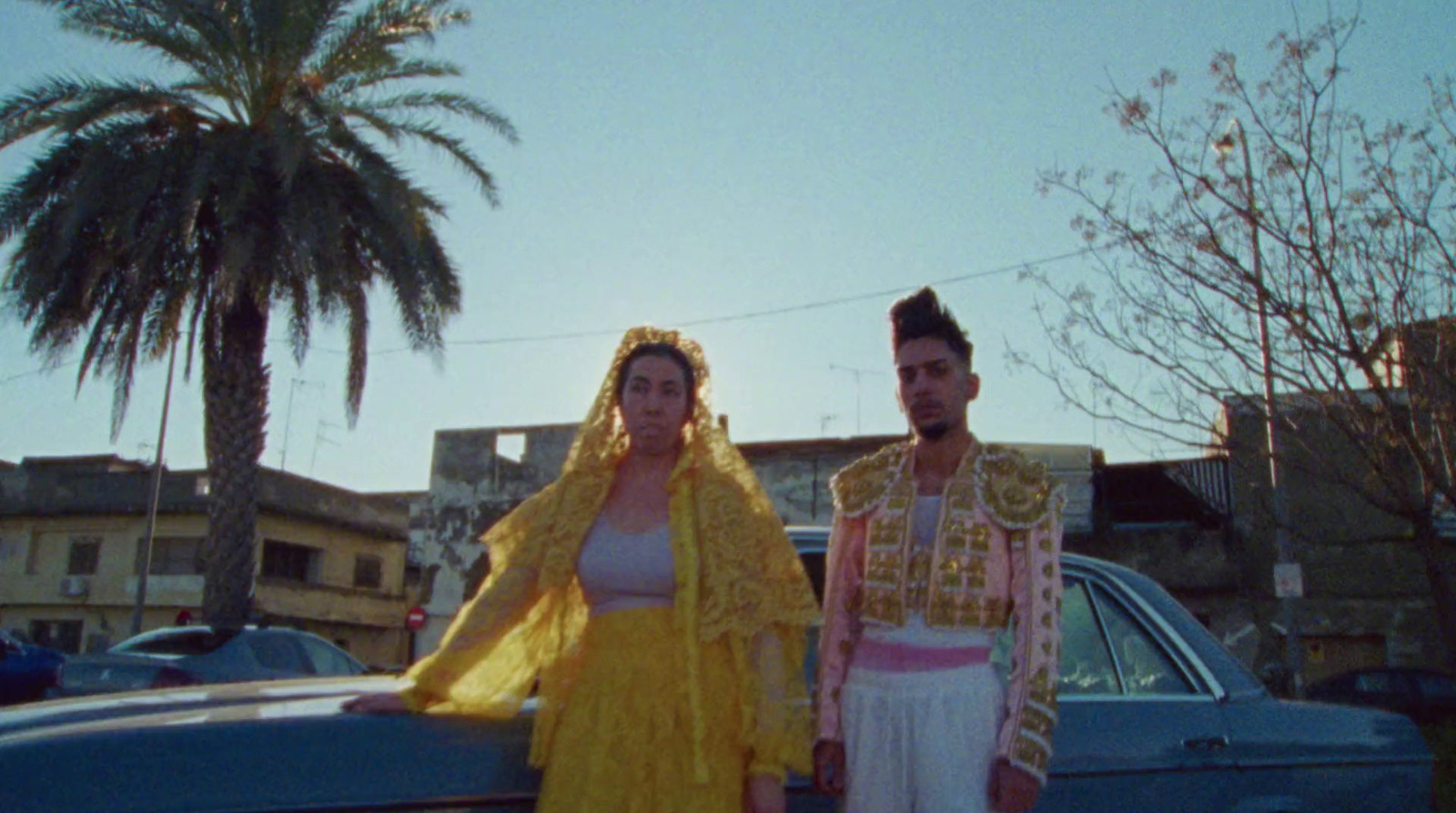 a man and a woman standing next to a car