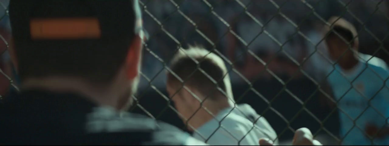 a group of people standing behind a chain link fence