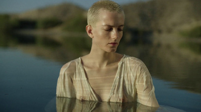 a woman standing in the water with her eyes closed