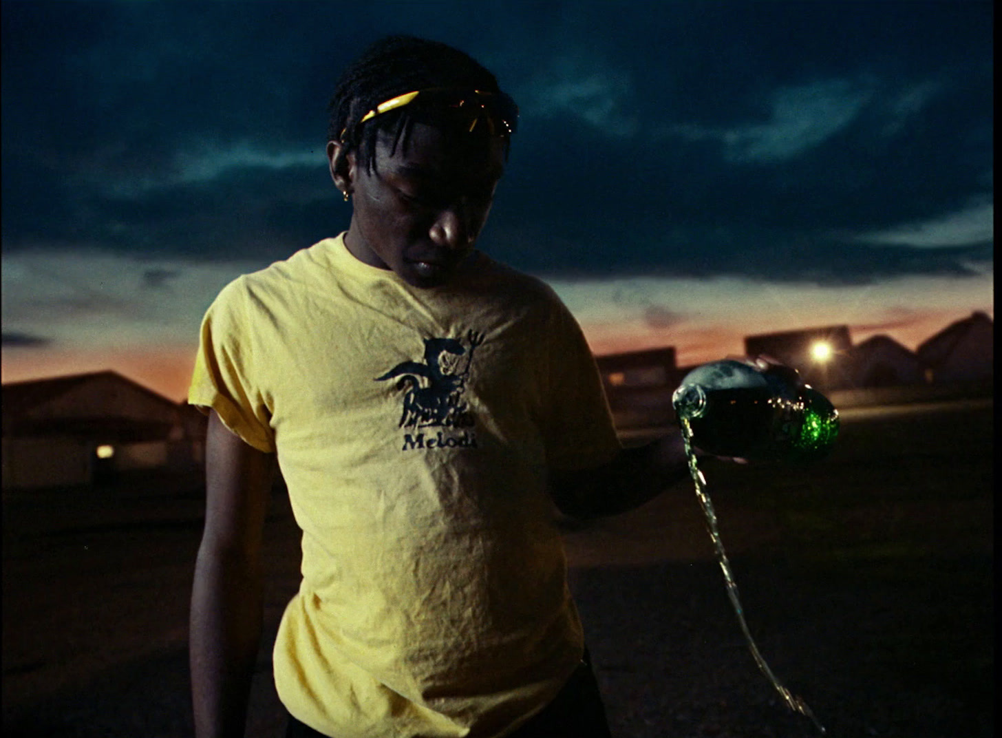 a man in a yellow shirt holding a water hose